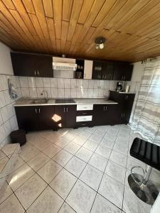 a kitchen with black cabinets and a wooden ceiling at Casa Ella Maldaresti in Măldăreşti
