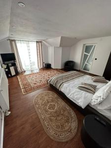 a bedroom with a large bed and a rug at Casa Ella Maldaresti in Măldăreşti
