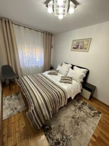 een slaapkamer met een bed en een kroonluchter bij Casa Ella Maldaresti in Măldăreşti
