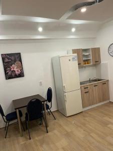 Una cocina con refrigerador y una mesa y sillas. en Bada Bing Plaza, en Bratislava