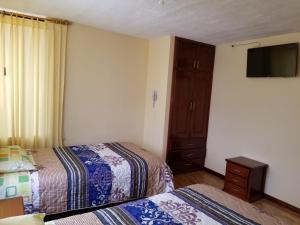 Postel nebo postele na pokoji v ubytování HOSTAL EL CONFORT QUITO NORTE