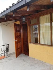 una entrada a un edificio con puerta de madera en HOSTAL EL CONFORT QUITO NORTE, en Quito