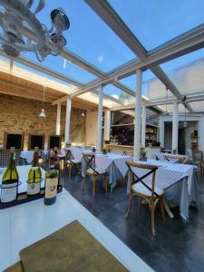 een restaurant met witte tafels en flessen wijn bij Cortona Resort & Spa in Cortona