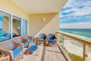 a balcony with chairs and a view of the ocean at The Beach Bounce in Pensacola Beach
