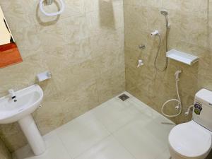 W łazience znajduje się prysznic, toaleta i umywalka. w obiekcie Coco Garden Holiday Homes w mieście Anuradhapura