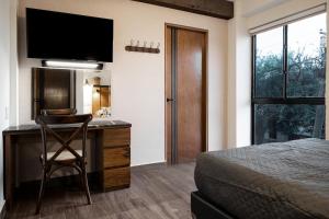 um quarto com uma cama e uma secretária com uma televisão em Espacioso, moderno con amenidades en Tulancingo 2 em Monterrey