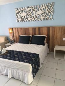 ein Schlafzimmer mit einem großen Bett und einer Holzwand in der Unterkunft Hotel Búzios Resort com Entretenimento in Búzios