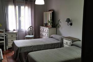 a bedroom with two beds and a desk and a dresser at CASA ISA, ideal para descansar. in Santa Cruz de la Palma