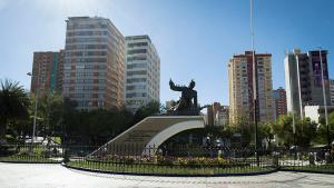 a statue in the middle of a city with buildings at Casa Abaroa in La Paz