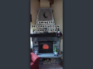 - une cheminée dans le salon avec un chien assis devant dans l'établissement Casa Vacanze: Maison Des Gnomes, à Challand Saint Anselme