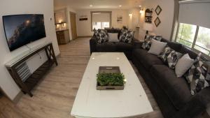 a living room with a couch and a tv at The Raspberry Garden Luxury Hotel & Suites in Rexburg