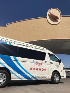 une camionnette blanche garée devant un bâtiment dans l'établissement Hotel San Angel, à Hermosillo