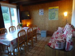 uma sala de jantar com uma mesa e uma mesa e cadeiras em La Bresse Hautes Vosges Chalet le Paiquis em La Bresse