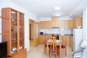 a kitchen with wooden cabinets and a table with chairs at Els Ports d'Horta in Horta de San Joan