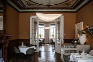 a dining room with tables and chairs and a ceiling at Villa Ostinato in Ostend