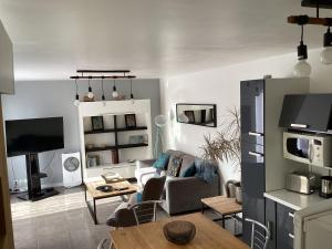 een woonkamer met een bank en een tafel bij Joli appartement 50 m2 classé 3 etoiles avec terrasse et jardin in La Rochelle