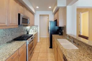 a kitchen with a stove and a sink and a refrigerator at LV305 Legacy Villas Townhome w Expansive Patio in La Quinta