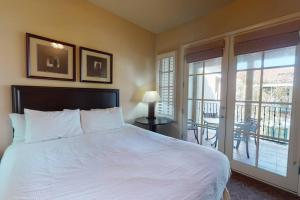 een slaapkamer met een groot wit bed en een balkon bij LV102 Upstairs 1 Bedroom Legacy Villas Delight in La Quinta