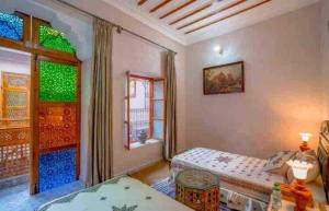 1 dormitorio con 2 camas y ventana en Dar lmrama Guest House Fes Medina Morocco en Fez