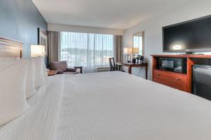 a hotel room with a large bed and a flat screen tv at The Ramsey Hotel and Convention Center in Pigeon Forge