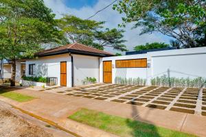 dom z dużą ilością trawy przed nim w obiekcie Calle 1 - 29 Tamarindo w mieście Tamarindo