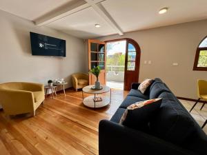 een woonkamer met een blauwe bank en een tv bij Santa Lucia Suites - Barranco in Cuenca