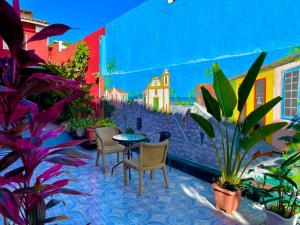a patio with a table and chairs and plants at Pousada Kawaii in Arraial d'Ajuda