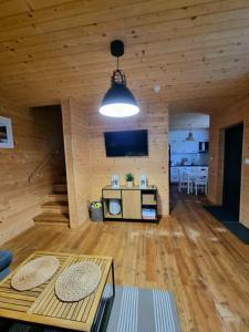 a living room with wooden walls and wooden floors at Fuledzki Biały Domek - Mazury, Jacuzzi, Sauna, Giżycko in Fuleda