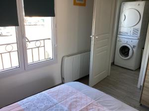 a bedroom with a washing machine and a washer and dryer at Chaleureux T2 30 m2 et sa terrasse bois 18 m2 in La Rochelle
