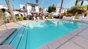 - une piscine dans un hôtel avec des palmiers dans l'établissement SV108 1 Bedroom Spa Villa w Incredible Views, à La Quinta
