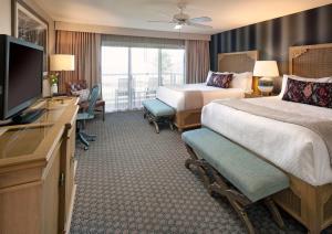 a hotel room with two beds and a flat screen tv at Spyglass Inn in Pismo Beach +27 photos