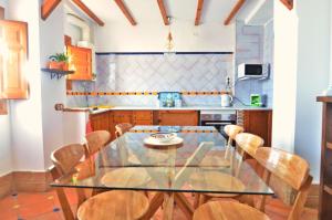 cocina con mesa de cristal y sillas en House&Cave Parking and Terrace, in the city en Granada