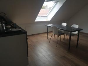 d'une salle à manger avec une table, des chaises et une fenêtre. dans l'établissement Messe Apartment BIN, à Hildesheim