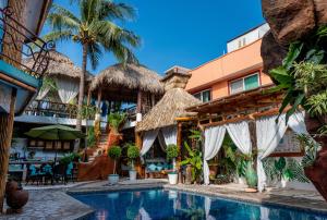 un complexe avec une piscine en face d'un bâtiment dans l'établissement Monyoli Hotel & Boutique, à Acapulco
