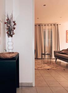 a living room with a vase of flowers on a table at Élégant T2 Blagnac - parking -aéroport-Airbus- Meett in Blagnac