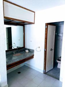 een badkamer met een wastafel, een spiegel en een toilet bij Hotel Mina in Mexico-Stad