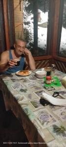 a man sitting at a table with a plate of food at Садиба Карпатський рай in Sheshory