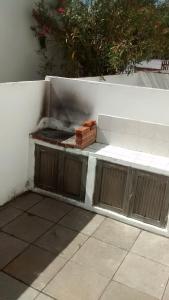 una parrilla de barbacoa al lado de una pared en Duplex en Mar del Tuyú en 