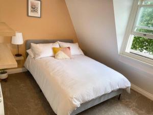 1 dormitorio con 1 cama blanca y 2 almohadas en Bristol townhouse with harbour views. Sleeps 7, en Bristol
