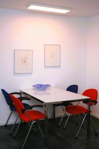 a table and four chairs in a room with paintings at Ferienwohnung Die Paradiesische in Kleve