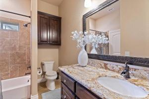 a bathroom with a sink and a toilet and a mirror at Lakeview Villa-we have boat rentals too! in Canyon Lake