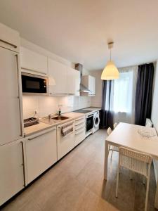 a kitchen with white cabinets and a table and a dining room at Apartment in the heart of Berlin 2122 in Berlin