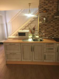 a kitchen with a sink and a staircase at Casa Corralazos in Castril +3 photos