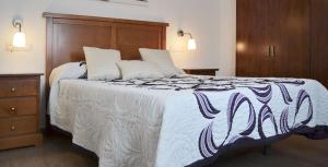 a bedroom with a large bed with a wooden headboard at Casa Corralazos in Castril