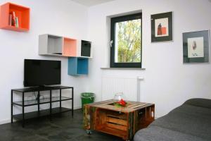 a living room with a tv and a coffee table at Ferienwohnung Die Paradiesische in Kleve