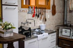 Casa Completa - Nova Petrópolis في نوفا بتروبوليس: مطبخ مع مغسلة وكاونتر مع اواني