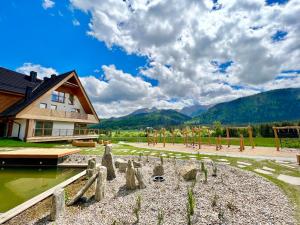 a house with a playground and mountains in the background at Apartamenty Riders Lodge Kościelisko Chotarz Bór in Kościelisko +38 photos