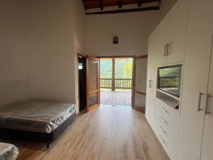 um quarto com uma cama e uma porta de vidro deslizante em Casa de luxo em Monte Verde em Camanducaia