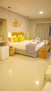 a bedroom with two beds with yellow pillows at Baía Branca Beach Resort in Tamandaré