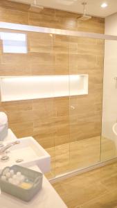 a bathroom with a sink and a glass shower at Baía Branca Beach Resort in Tamandaré